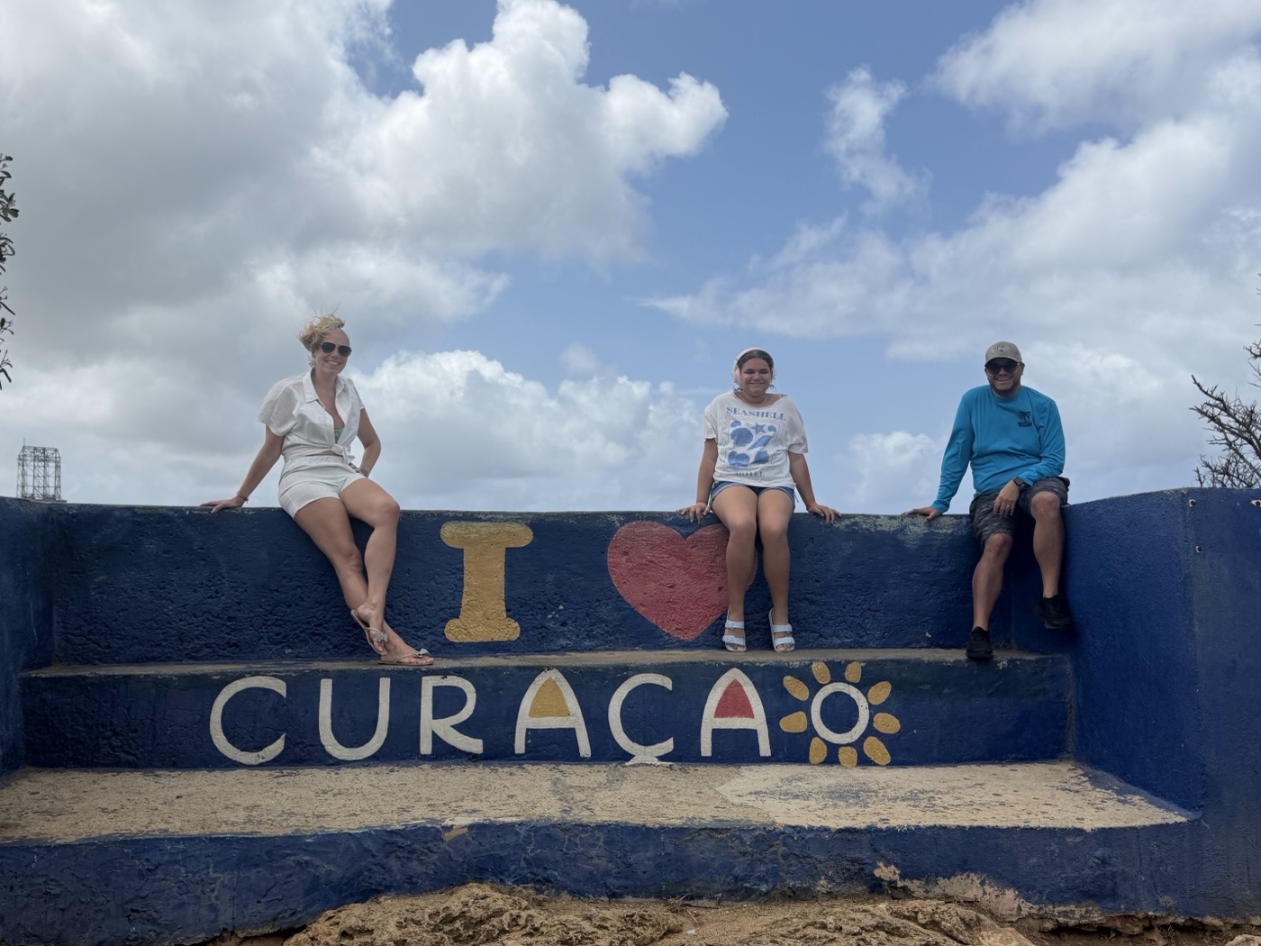 Sitting on the painted I love Curacao wall at an overlook