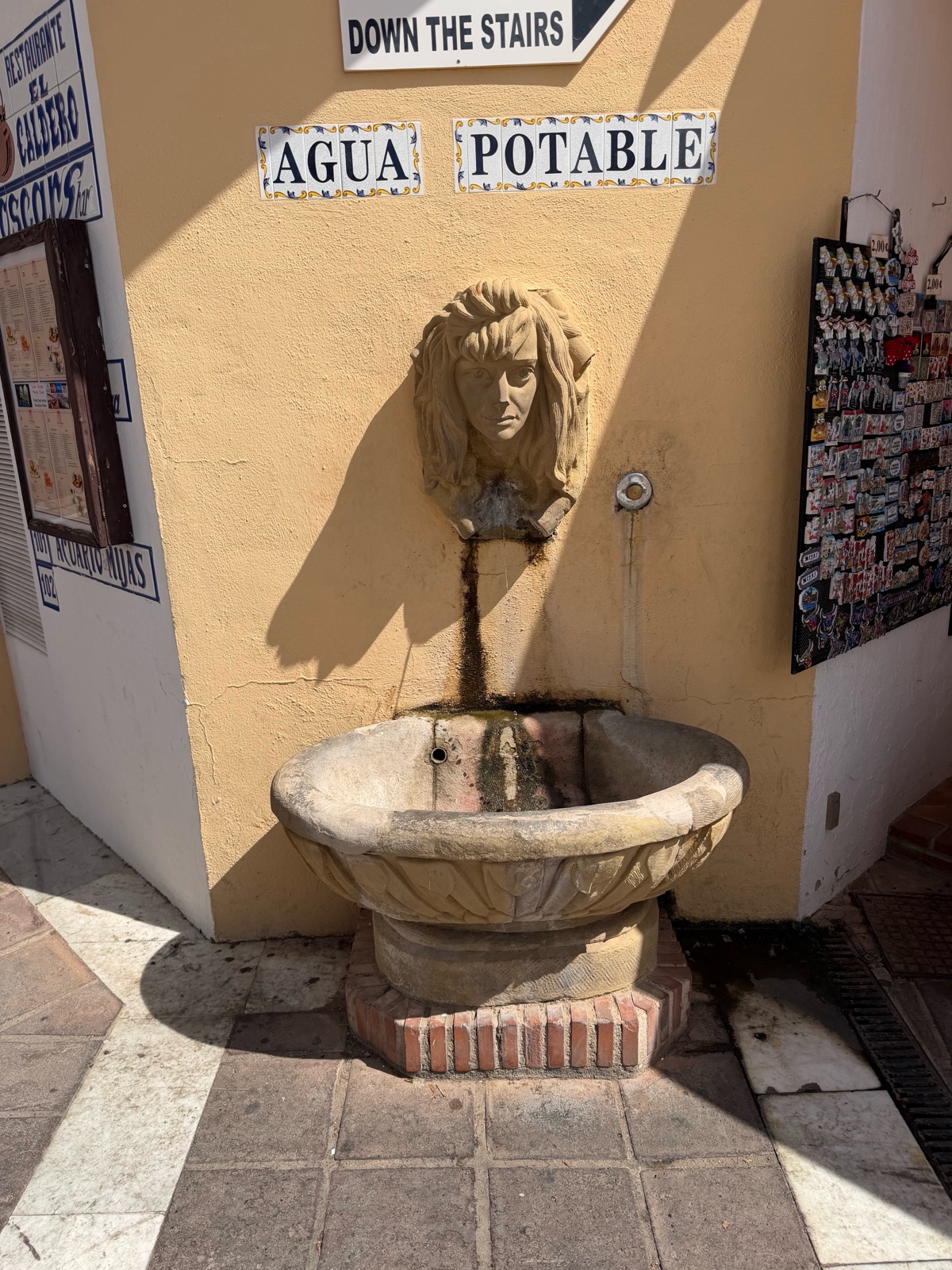 A stone drinking fountain set into a wall in Mijas
