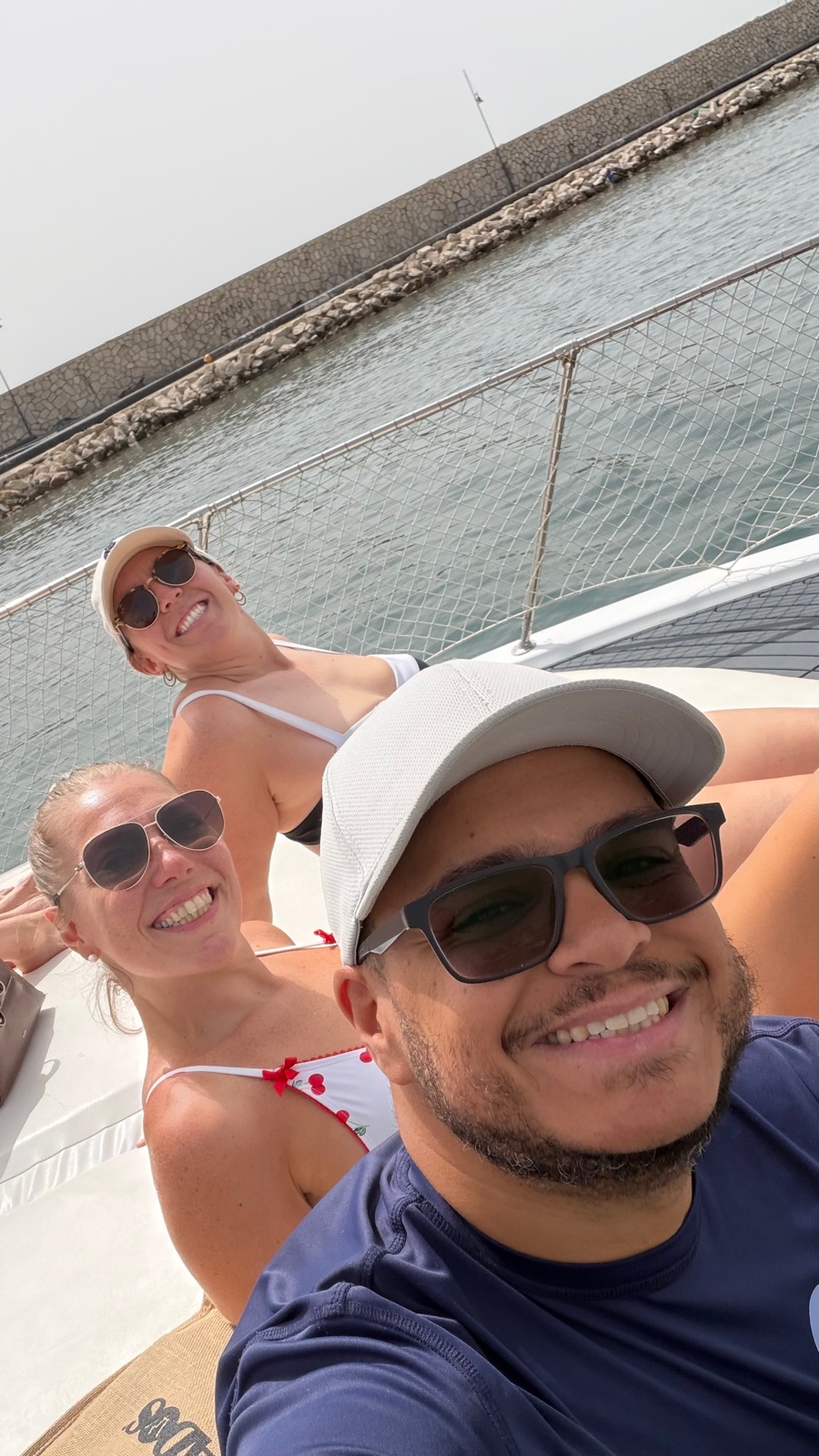 Miguel, Ashley and Jordan on the deck of the sailboat in the marina