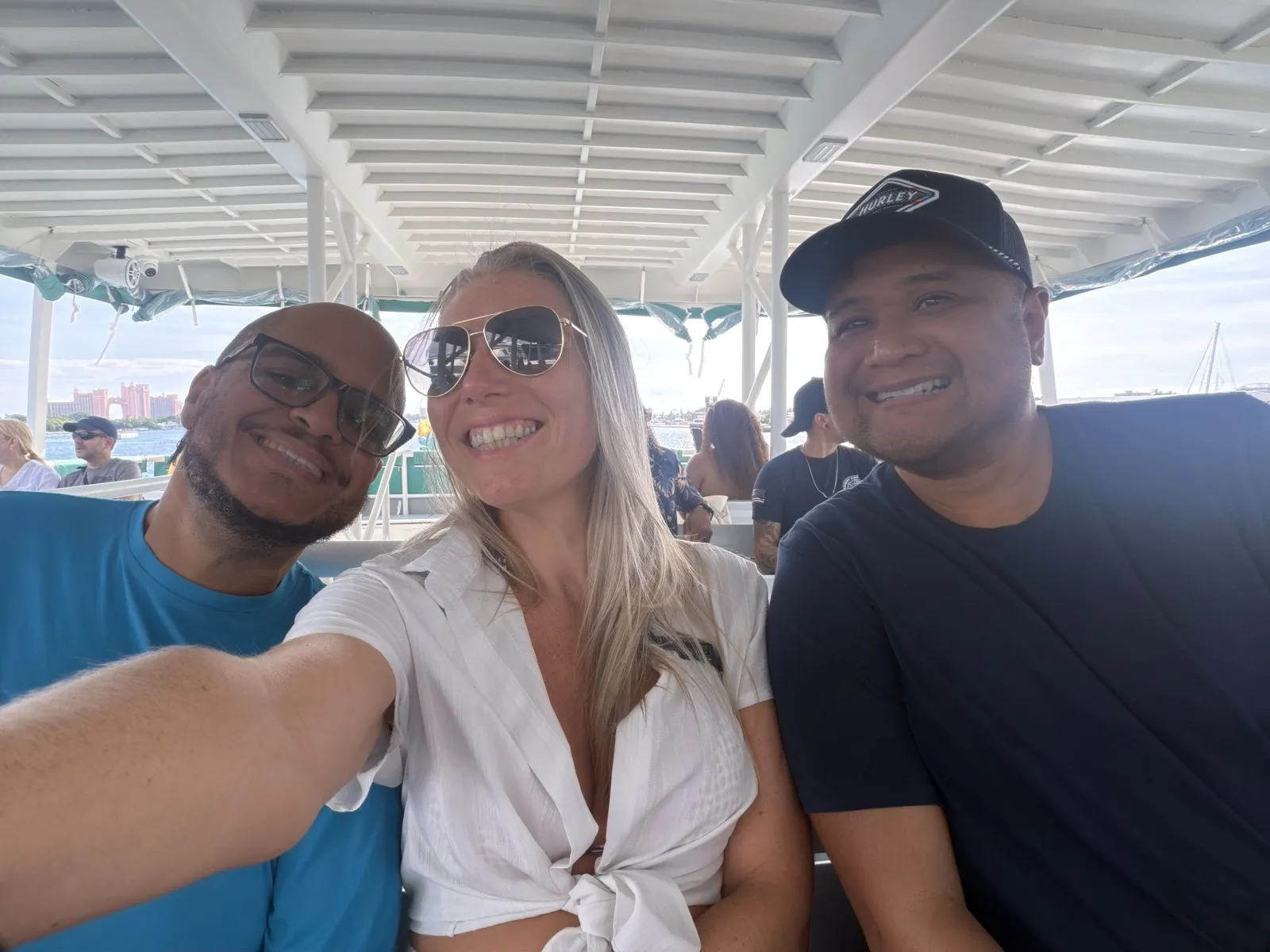 Miguel, Paolo and Miguel's wife Ashley taking a selfie on the covered boat to Royal Beach Club, with Atlantis in the background